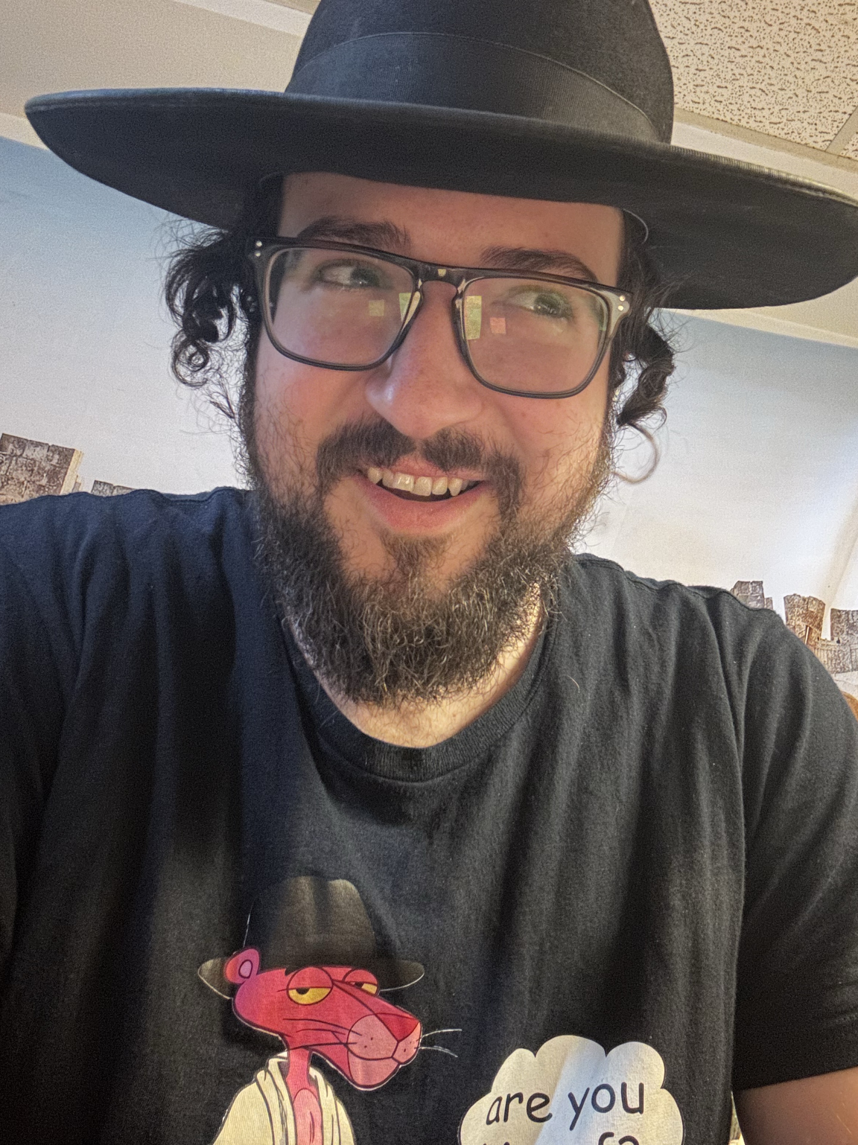 Rabbi Doniel Aryeh, smiling in his black hat and glasses